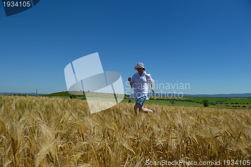 Image of young woman in wheat field at summer