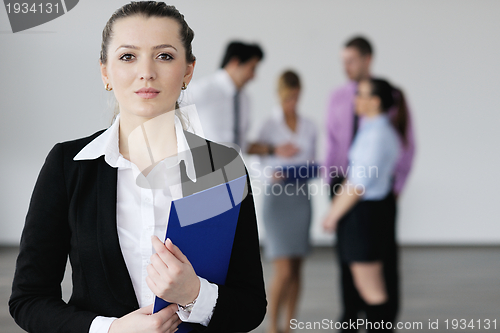 Image of business woman standing with her staff in background