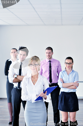 Image of business woman standing with her staff in background
