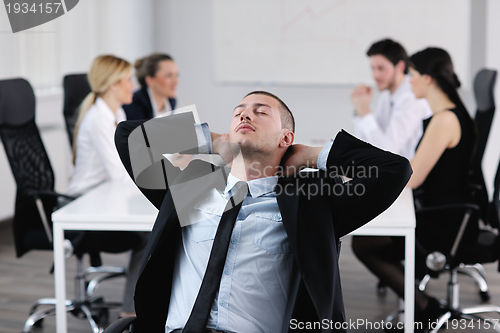 Image of Portrait of a handsome young business man with colleagues in bac