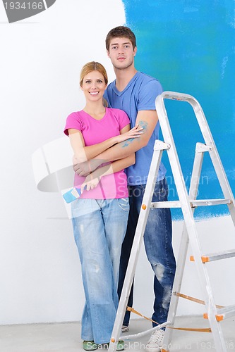 Image of happy couple paint wall at new home