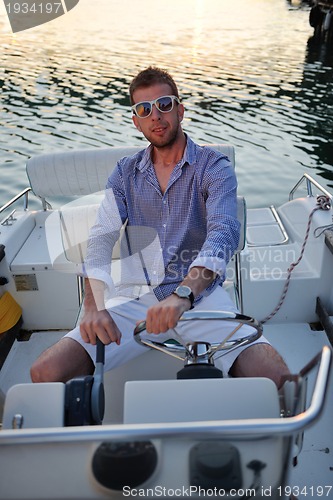 Image of portrait of happy young man on boat
