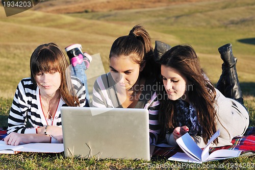 Image of group of teens working on laptop outdoor