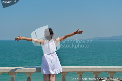 Image of young woman with spreading arms to sky