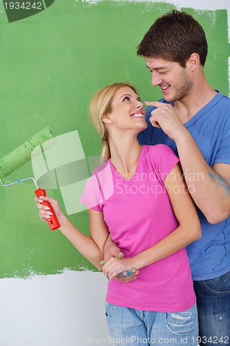 Image of happy couple paint wall at new home