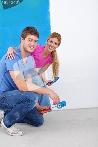 Image of happy couple paint wall at new home