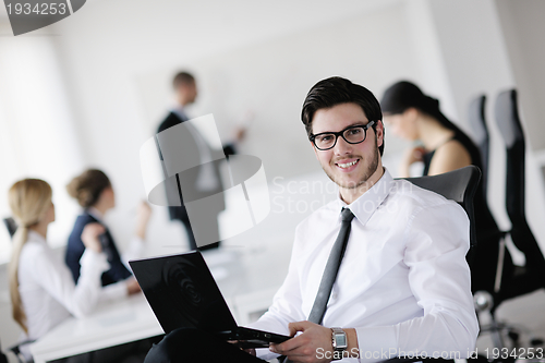 Image of Portrait of a handsome young business man with colleagues in bac