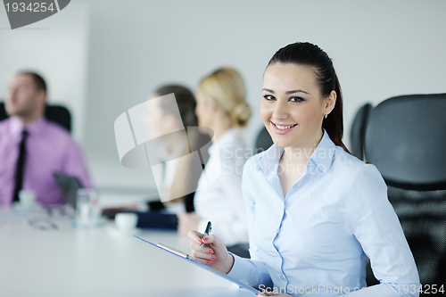 Image of business woman standing with her staff in background