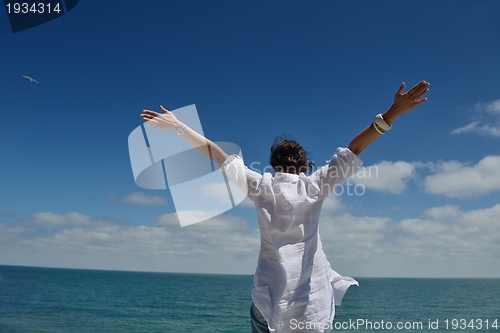 Image of young woman with spreading arms to sky
