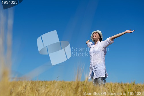 Image of young woman in wheat field at summer
