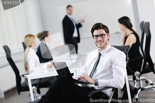 Image of Portrait of a handsome young business man with colleagues in bac