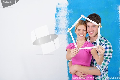 Image of happy couple paint wall at new home