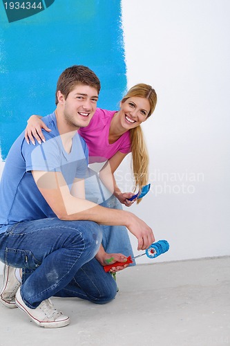 Image of happy couple paint wall at new home