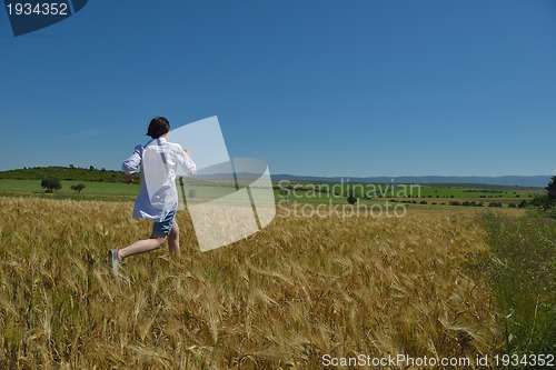Image of young woman in wheat field at summer