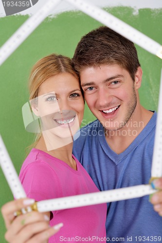 Image of happy couple paint wall at new home