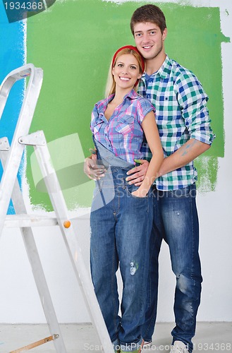 Image of happy couple paint wall at new home