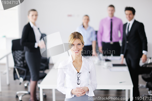 Image of business woman standing with her staff in background