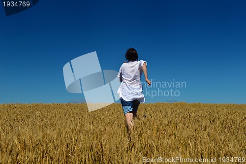 Image of young woman in wheat field at summer