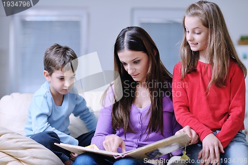 Image of young mom play with their kids at home and reading book