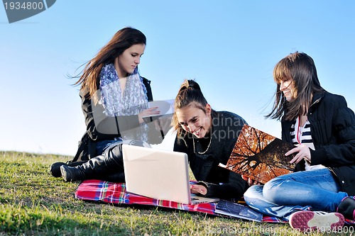 Image of group of teens working on laptop outdoor