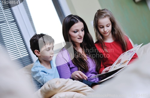 Image of young mom play with their kids at home and reading book