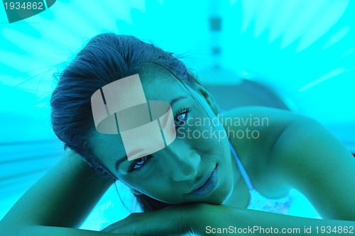 Image of Beautiful young woman tanning in solarium