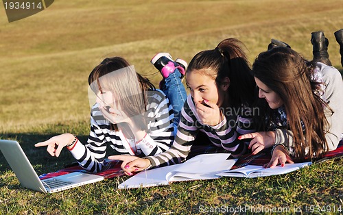 Image of group of teens working on laptop outdoor