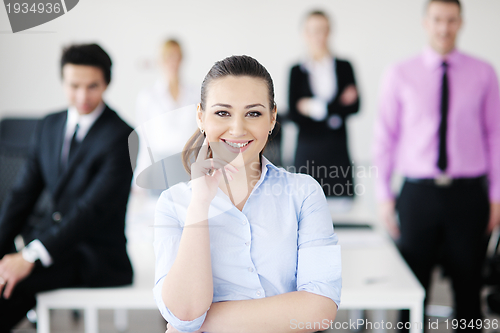Image of business woman standing with her staff in background