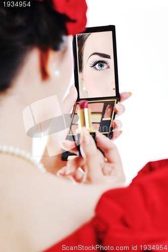 Image of beautiful young woman applying makeup