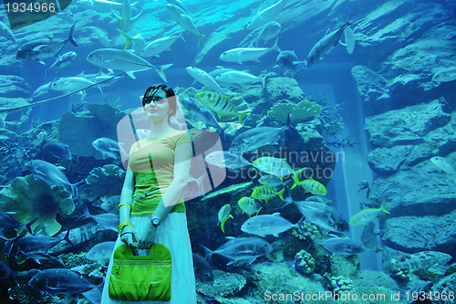 Image of young woman with big aquarium in backgrond