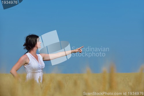 Image of young woman in wheat field at summer