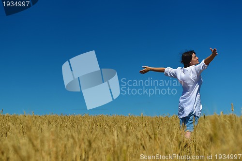 Image of young woman in wheat field at summer