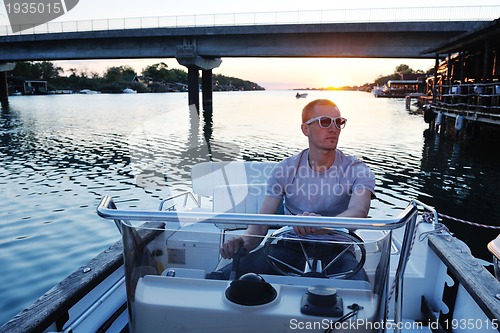 Image of portrait of happy young man on boat