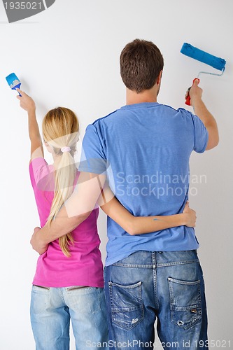 Image of happy couple paint wall at new home