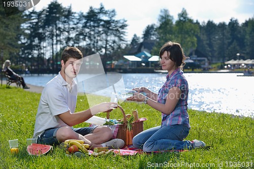Image of happy young couple having a picnic outdoor