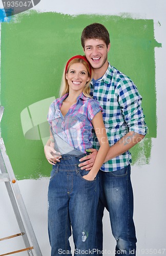 Image of happy couple paint wall at new home