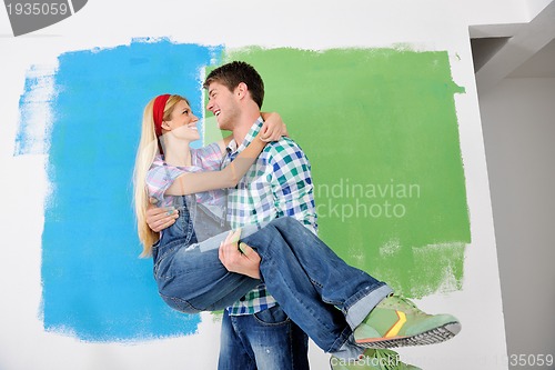 Image of happy couple paint wall at new home