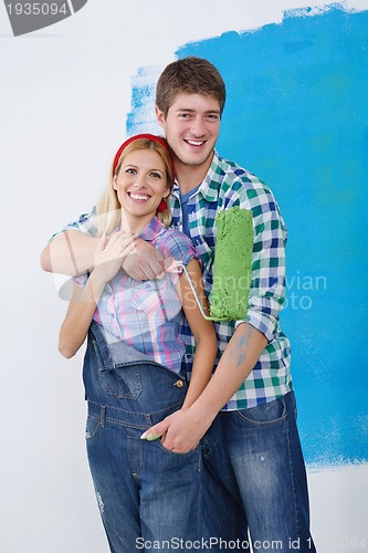 Image of happy couple paint wall at new home