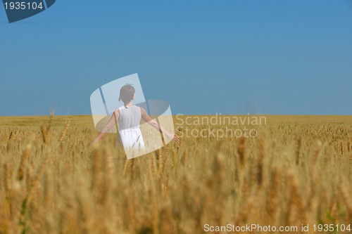 Image of young woman in wheat field at summer