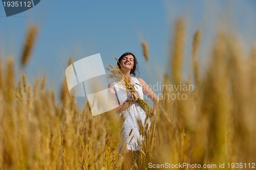 Image of young woman in wheat field at summer