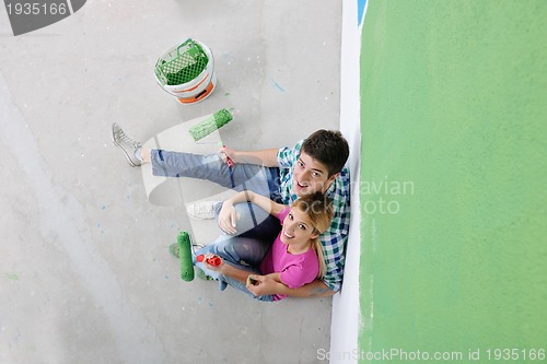 Image of happy young cople relaxing after painting in new home