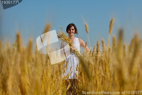 Image of young woman in wheat field at summer