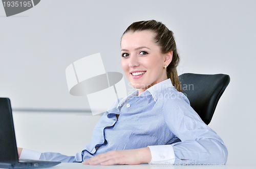 Image of business woman standing with her staff in background