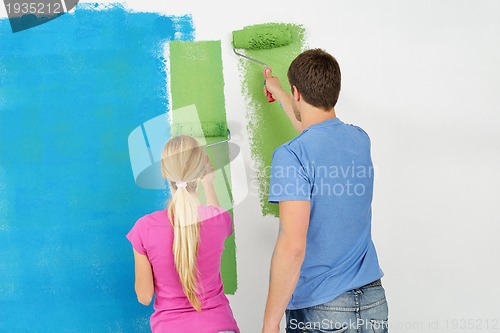 Image of happy couple paint wall at new home