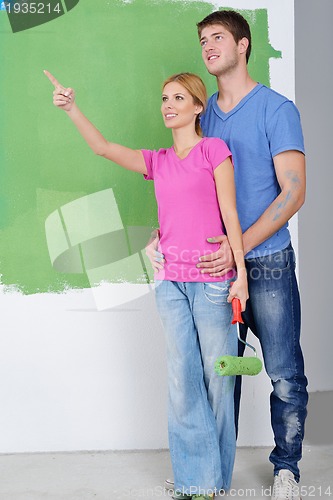 Image of happy couple paint wall at new home