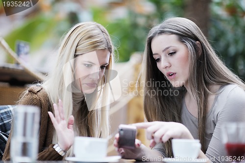Image of cute smiling women drinking a coffee