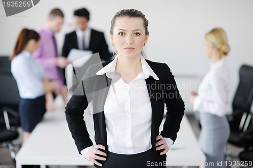 Image of business woman standing with her staff in background