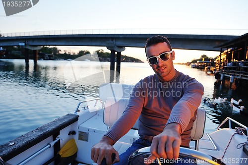 Image of portrait of happy young man on boat