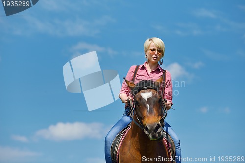 Image of happy woman  on  horse