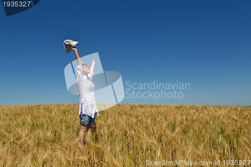 Image of young woman in wheat field at summer